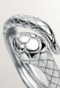 Pulsera de plata en forma de serpiente con un diseño texturizado y escamoso, que presenta un acabado brillante y detalles pronunciados en la cabeza. Forma circular y flexible.