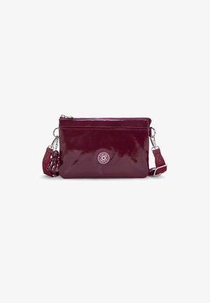 Borsa a tracolla in pelle verniciata bordeaux con chiusura a zip, dettaglio del logo circolare e charm staccabile sul manico. Texture liscia.