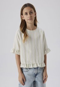 Top bianco con strisce verdi, maniche e orlo arricciati, abbinato a pantaloni shorts in denim azzurro chiaro, caratterizzati da una vestibilità rilassata e una trama morbida.