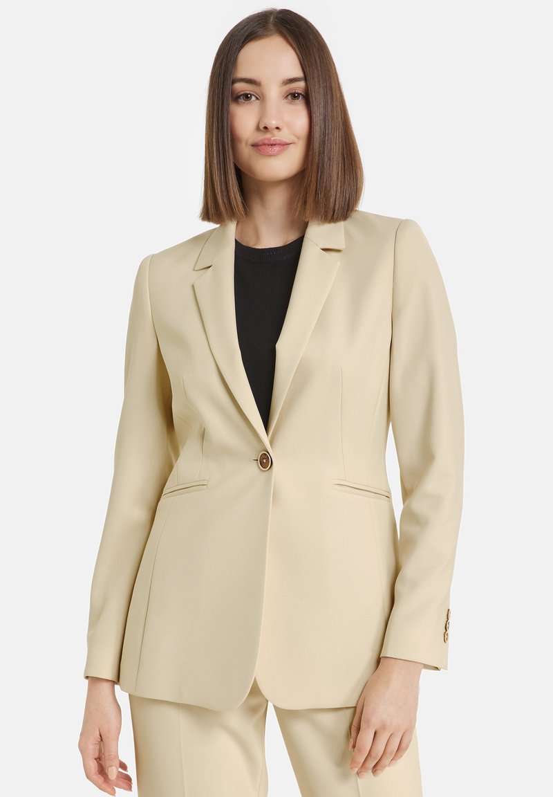 Beige blazer made of smooth fabric, featuring a notched lapel, single button closure, two front pockets, and subtle seam detailing.