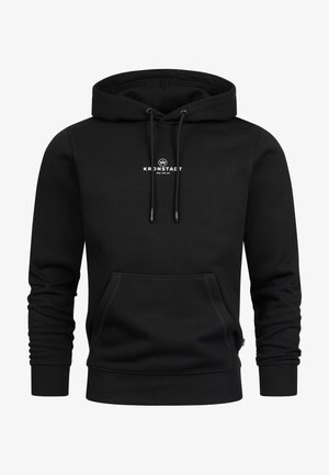 Svart hettegenser laget av mykt stoff, med frontlomme i kengurustil, ribbestrikkede mansjetter, snor i hetten og en liten logo trykt på brystet.