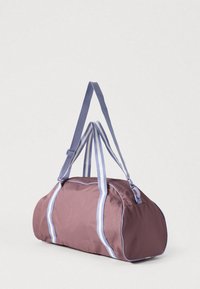 Τσάντα duffle σε υφασμάτινο μωβ με ανοιχτό μπλε ρίγες και λουριά. Διαθέτει φερμουάρ και στρογγυλεμένο σχήμα για εύκολη μεταφορά.