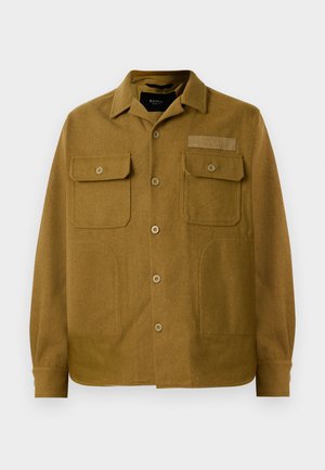 Giacca camicia in lana marrone con colletto a punta, due tasche sul petto e chiusura frontale con bottoni. Tessuto testurizzato con un motivo sottile.