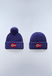 Két kék, kötött téli sapka norvég zászlóval díszítve; az egyik pom-pommal a tetején, a másik sima, mindkettő világos háttér előtt.