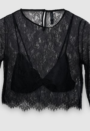 Haut à manches longues en dentelle noire avec un bralette noir ajusté en dessous. Motif floral transparent avec un ourlet festonné et une fermeture au dos en forme de trou de serrure.