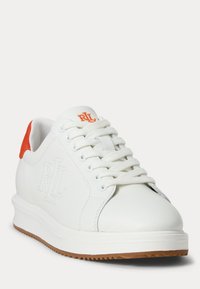 Hvit sneakers med preget logo og oransje hæl-accent. Laget av glatt lær med rund tå og teksturert gummisåle.