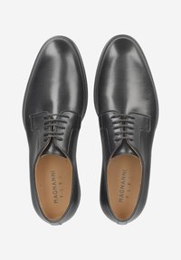 Chaussures habillées en cuir noir à finition lisse, design à lacets, bout arrondi et coutures minimales. Intérieur en cuir tanné clair avec logo de la marque visible.