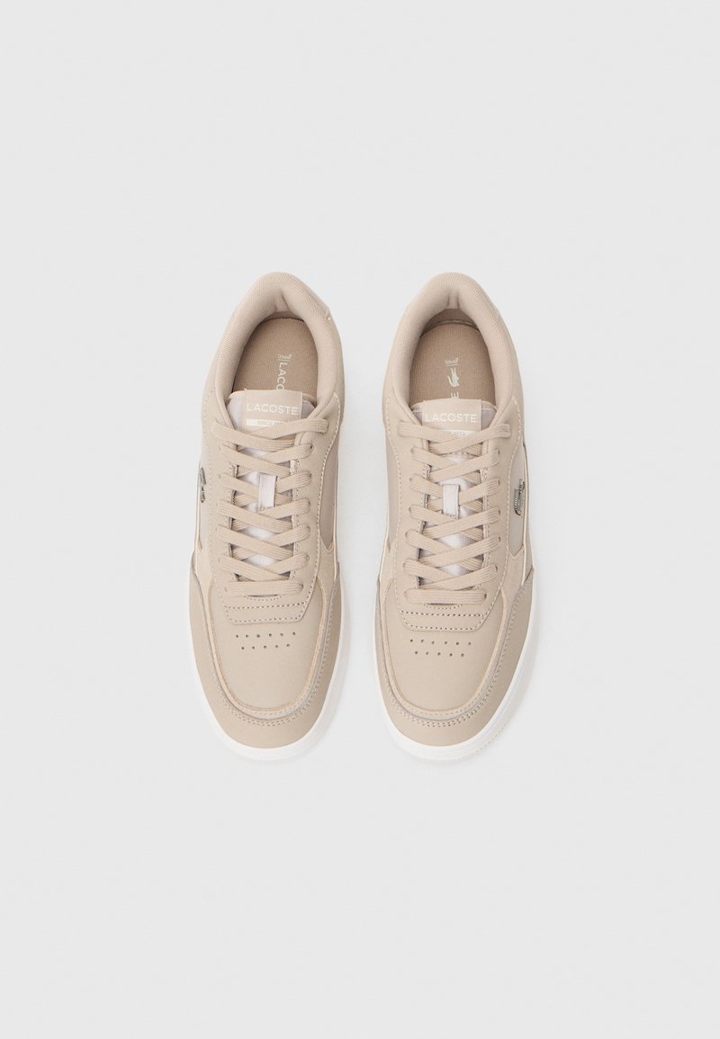 Beige sneakers with a smooth leather upper, perforated toe, and contrasting white rubber sole. Features laces and a logo detail on the side.