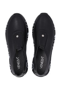 Zwarte synthetische instapschoenen met een textuur bovenwerk, voorzien van een ronde neus en een contrasterende witte patroonzool. Accent van zilverkleurig hardware.