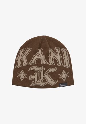 Bruine gebreide beanie met grote beige letters "KANI" en decoratieve sterpatronen. Inclusief een zwart label met kenmerkende details.