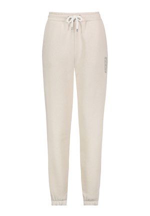 Beige cotton sweatpants with elastic waistband, drawstring, and ribbed cuffs. Features printed text detail on the side.