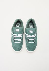Baskets en suède vert avec des lacets blancs et une languette rembourrée. Comprend un patch logo ovale et des détails perforés sur le bout. Semelle en caoutchouc.