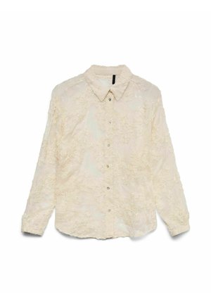 Chemise blanche avec broderie florale, boutons sur le devant et col. Comprend des manches longues et une texture légèrement transparente.