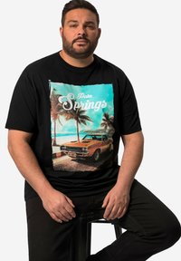 Černé tričko s grafickým potiskem oranžového klasického auta na pozadí pláže s palmami, text "Palm Springs" v bílé barvě.