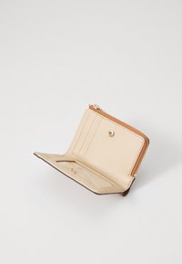 Portefeuille en cuir tan avec fermeture éclair. Comprend un emplacement pour cartes à l'intérieur, une fenêtre ID transparente et des accents cousus à l'extérieur.