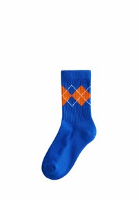 Blaue gerippte Socke mit einem Rautenmuster in Orange und Weiß. Sie hat einen einfarbigen Körper und ein kontrastierendes Design nahe dem Bündchen.