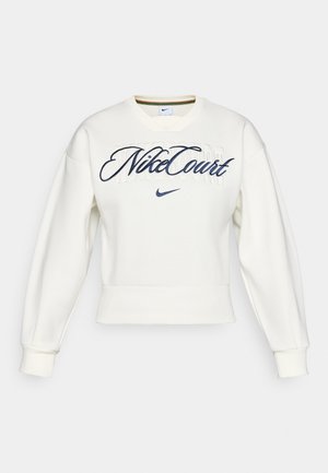 Balts Nike džemperis ar uzrakstu "NikeCourt" izšūdinātā tumši zili kursīvā virs uzdrukātiem bloknotiem, ar nelielu tumši zilu Nike zvīņainu simbolu zemāk.
