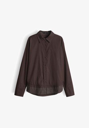 Dunkelbraunes Langarm-Hemd mit Knöpfen und Kragen, das einen kontrastierenden gestreiften Stoff aus dem Saum hervorblitzen lässt.