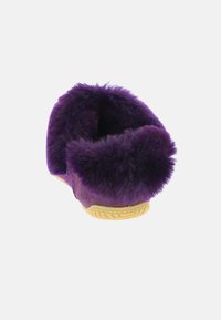 Lila mockasiner i mocka med mjukt foder av päls, rundad form och gummisula med texturerat grepp för stabilitet.