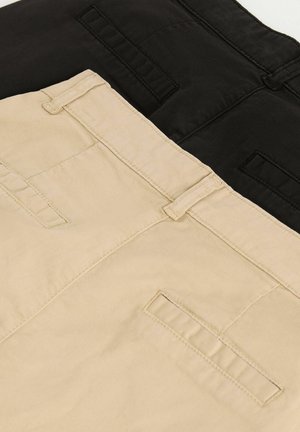 Divas bikses pāri attēlotas. Vienas ir melnas, otras bēšas. Abām ir gluda, matēta tekstūra un aizmugures kabatas ar horizontālām atverēm.