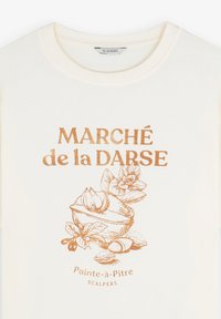 Crèmekleurig katoenen t-shirt met een metallic koperen artwork van een schelp en bloemen, met de tekst "MARCHÉ de la DARSE" en "Pointe-à-Pitre".
