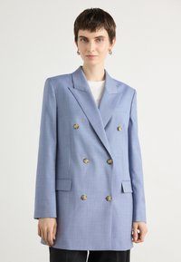 Dvojradový modrý blazer z textilného materiálu s klopami, dvoma prednými vreckami a dekoratívnymi gombíkmi. Upravený strih, dlhé rukávy.