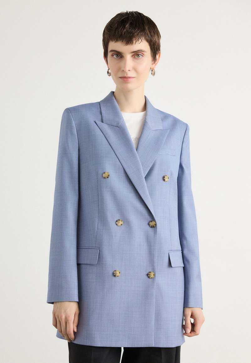 Dvojradový modrý blazer z textilného materiálu s klopami, dvoma prednými vreckami a dekoratívnymi gombíkmi. Upravený strih, dlhé rukávy.