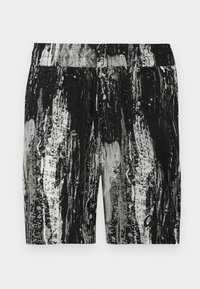 Schwarz-weiße Shorts mit Muster, die ein strukturiertes Design, einen elastischen Bund und eine lockere Passform aufweisen. Auffällige Farbkontraste und Spritzerdetails.
