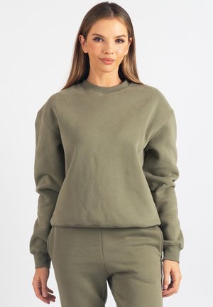 Bluza oliwkowozielona z okrągłym dekoltem, opuszczonymi ramionami i ściągaczami przy mankietach. Wykonana z miękkiego, teksturowanego materiału. Prosty, luźny krój.