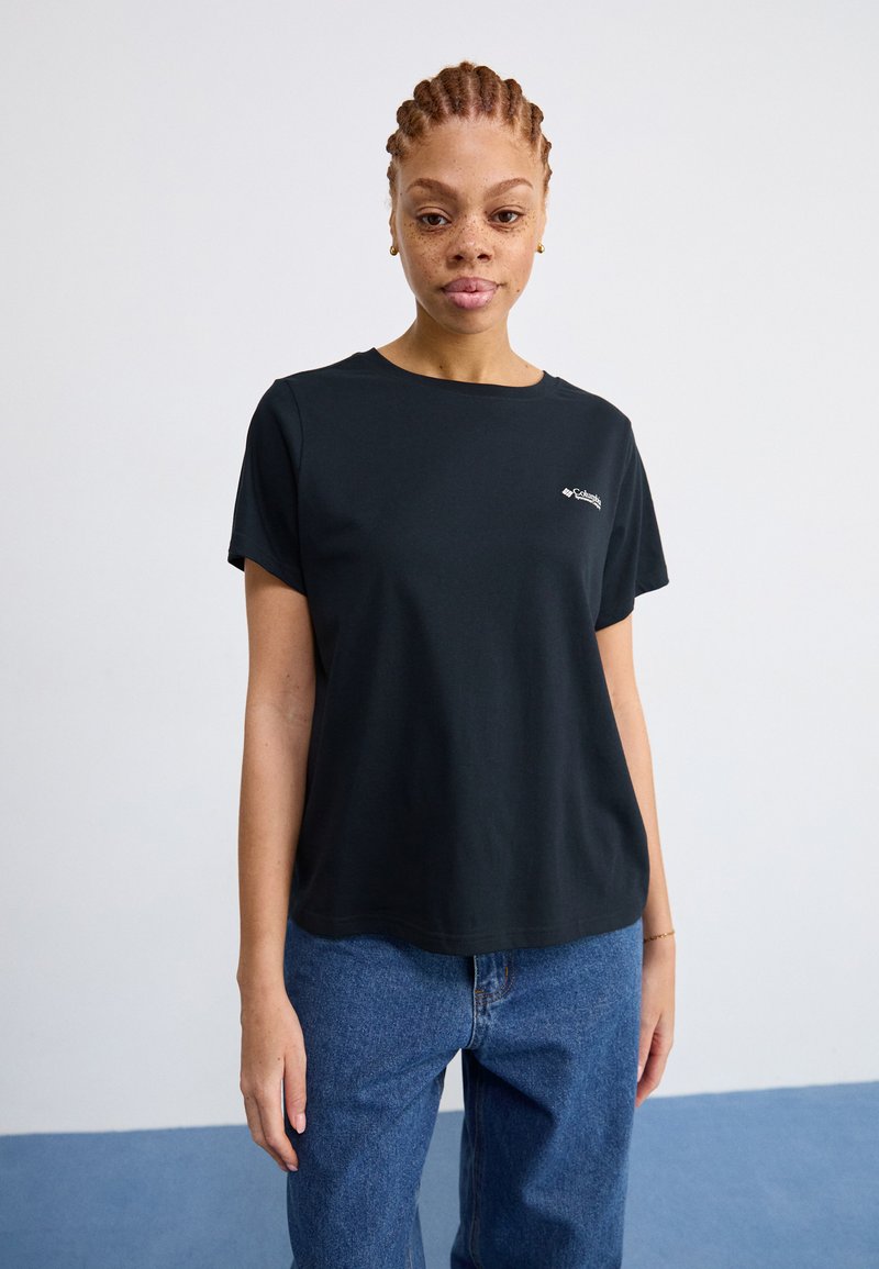 Schwarzes T-Shirt mit kurzen Ärmeln und Rundhalsausschnitt, mit subtiler Markenlogo auf der Brust, kombiniert mit blauen Jeans.