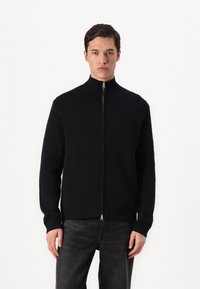 Black zip-up sweater with a high ribbed collar, made from a smooth material. Features long sleeves and a fitted design.