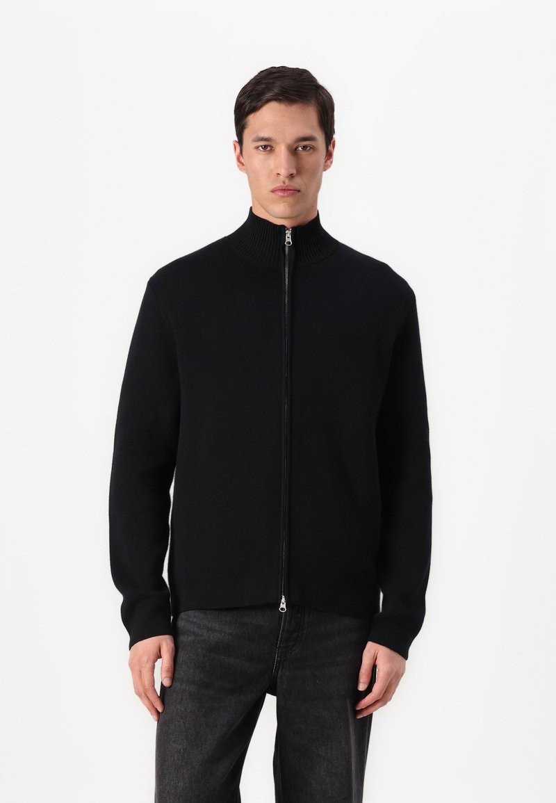 Black zip-up sweater with a high ribbed collar, made from a smooth material. Features long sleeves and a fitted design.