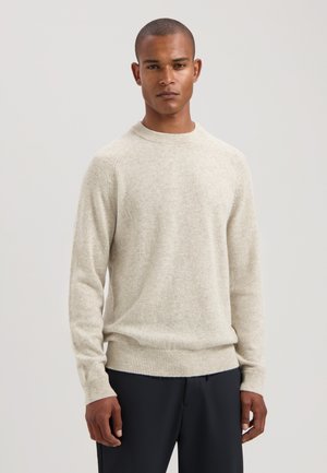 Hellbeige gestrickter Pullover mit Rundhalsausschnitt, gerippten Bündchen und Saum. Weiche Textur, normale Passform und Raglanärmel.