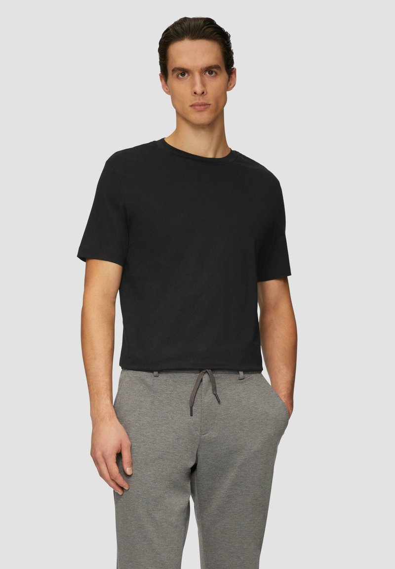 Zwarte T-shirt met korte mouwen van katoen, ronde halslijn, gecombineerd met grijze sweatpants met een trekkoord. Eenvoudig ontwerp, casual pasvorm.