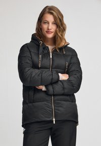 Czarna kurtka puchowa z kapturem, z złotymi akcentami na sznurkach i suwakach. Lekka, pikowana konstrukcja z zapinanym na zamek przodem.