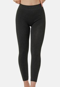Leggings neri realizzati in un tessuto morbido e elasticizzato. Presentano una vita alta e gambe aderenti che si stringono alla caviglia.