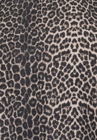 Luipaardprint stof met een beige achtergrond en zwarte vlekken, met een textuur die typisch is voor denim materiaal.