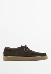 Brown suede shoes with round toe, lace-up design, and contrasting beige rubber sole. Features stitching detail along the edge.