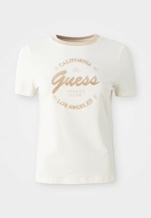 T-shirt crème à manches courtes avec un col rond, ornée de broderies dorées texturées portant l'inscription "Guess Sports Club California Los Angeles."