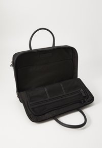 Schwarze Laptoptasche mit strukturiertem Reißverschluss, ausgestattet mit zwei Griffen, einem inneren Netzfach und einer flachen Tasche zur Organisation.