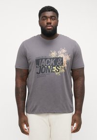 Gray cotton T-shirt with short sleeves, featuring a graphic design with palm leaves and "JACK & JONES" text in dark and light colors.