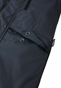 Ciemnoniebieska wodoodporna kurtka z gładką fakturą, z zamykaną na zamek kieszenią i zatrzaskami. Metka widoczna z boku.