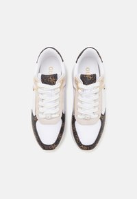 Baskets de sport blanches avec des accents à motifs noirs et marron, en matériaux en daim et en mesh, avec des détails en logo doré sur les côtés.
