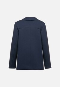 Cappotto blu navy con un design strutturato, dotato di colletto, maniche lunghe e dettagli di cucitura minimalista sul retro.