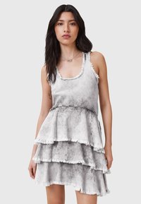 Vestido de capas en tonos gris y blanco con un dobladillo deshilachado, hecho de una tela ligera, con tirantes tipo tank y una cintura ajustada.