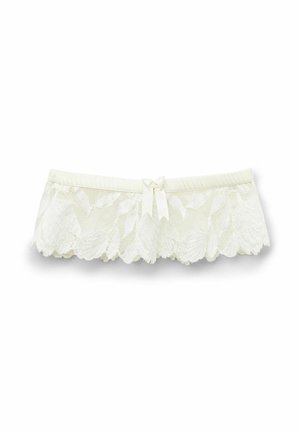 Lingerie in pizzo con bordi ondulati, colore crema, fascia elastica in vita e un dettaglio a fiocco al centro. Texture morbida con motivo floreale.