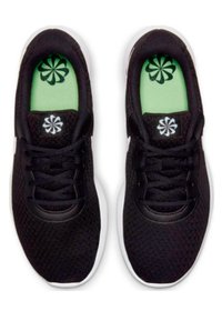 Zapatillas deportivas negras con parte superior de malla, suela blanca y plantilla verde con un patrón floral. Cordones y logo en colores contrastantes.