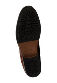Suela de un zapato de cuero marrón con una suela de goma negra que cuenta con surcos angulares y un patrón elevado central.