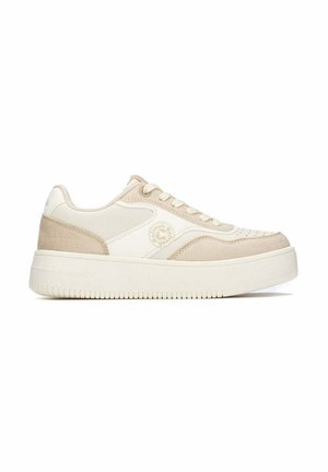 Zapatilla de plataforma baja en beige y blanco roto con detalles en ante y puntera redonda, con un logotipo circular en el lateral y cierre de cordones.