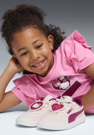 Lyserøde sneakers med hvide såler, prydet med Hello Kitty grafik, burgunder detaljer og et unikt rundt snørelåsesystem.